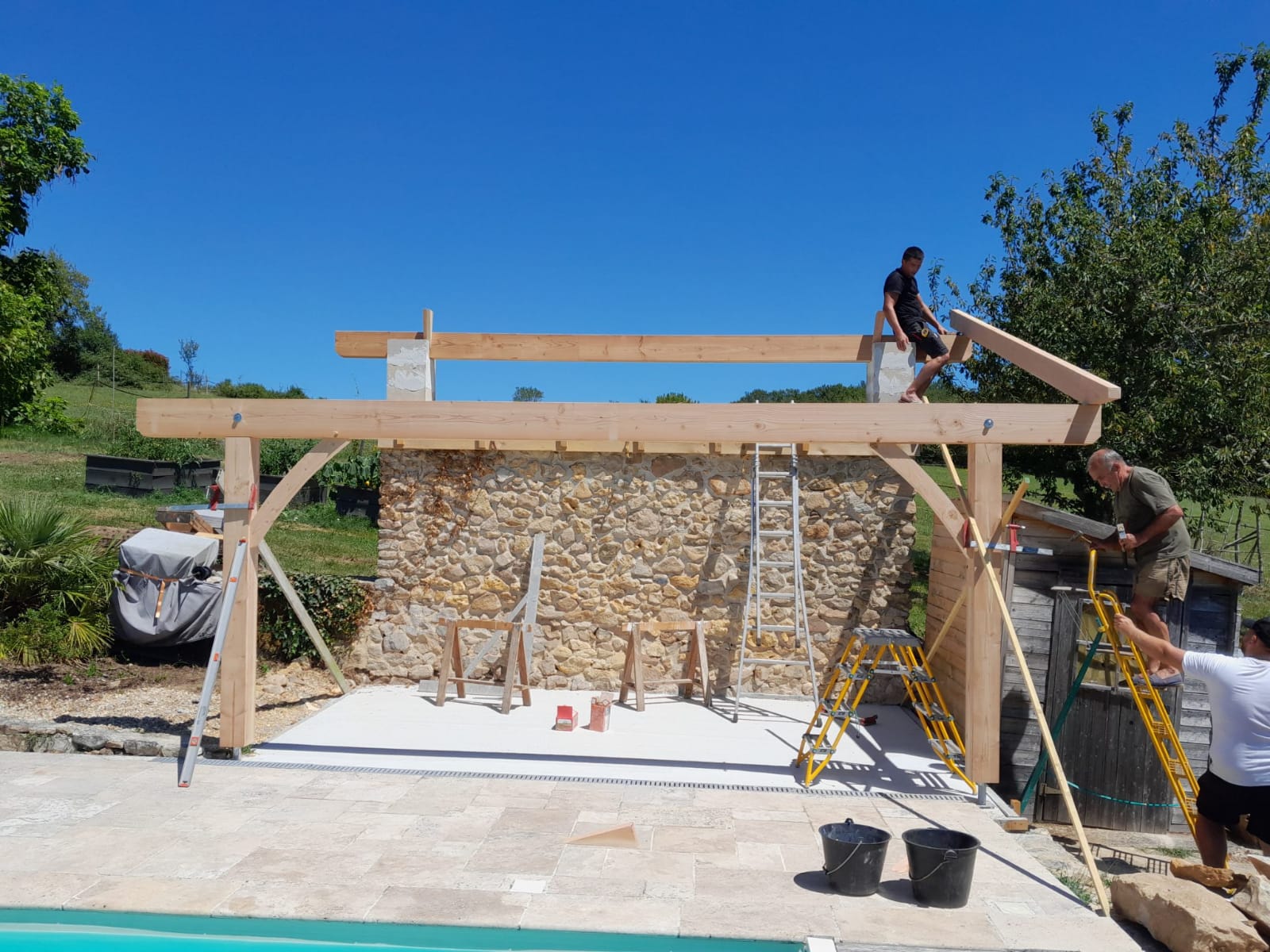 Construction d’un auvent en bois devant un mur en pierre à Bergerac